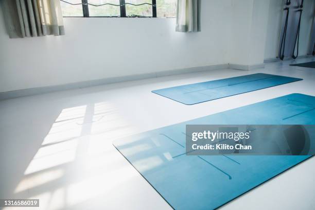 exercise mats on the floor of yoga studio during the day - mat stock pictures, royalty-free photos & images