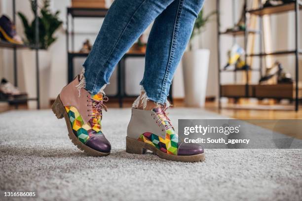 woman trying on shoes in fashion store - leather boot stock pictures, royalty-free photos & images