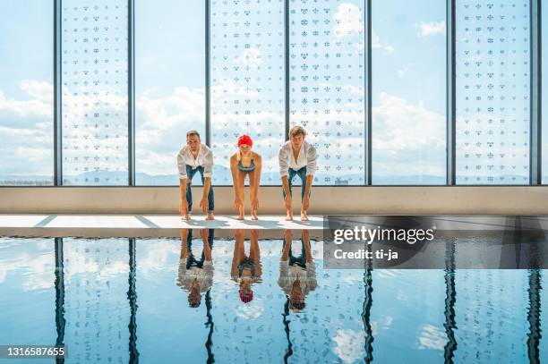 drei junge erwachsene am fenster in der nähe des schwimmbades - darstellender künstler stock-fotos und bilder