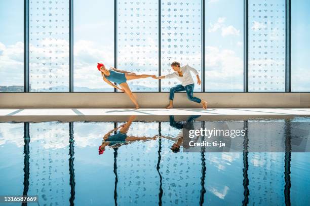 young couple performimg by the swimming pool - international artists stock pictures, royalty-free photos & images