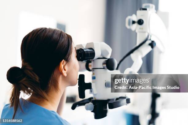 asian dentist examining teeth with modern equipment in clinic. - root canal procedure stock pictures, royalty-free photos & images