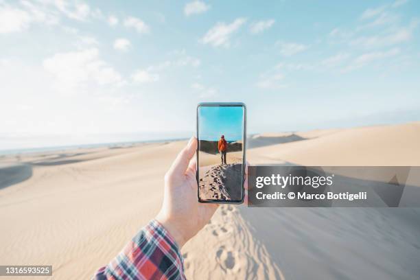 personal perspective of person photographing friend over sand dunes, maspalomas, spain - walking personal perspective stock pictures, royalty-free photos & images