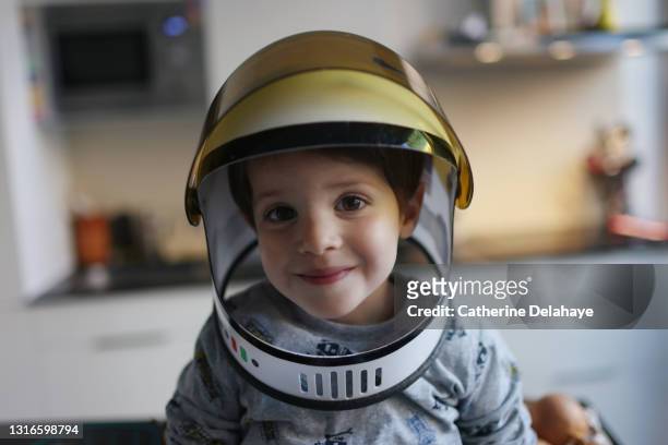 portrait of a little boy wearing an astronaut helmet - kids imagination imagens e fotografias de stock