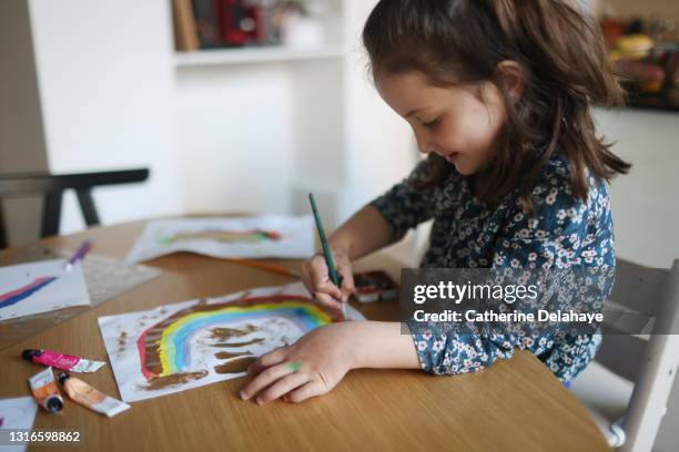 a little girl painting in the kitchen - coloring stockfoto's en -beelden