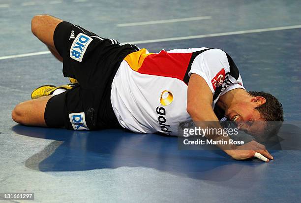 Adrian Pfahl of Germany lies injured on the floor during the Mens' Handball Supercup match between Germany and Spain at Gerry Weber stadium on...