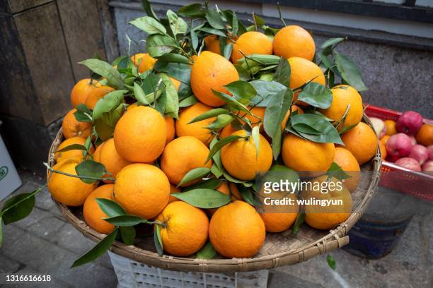 oranges stacked in a big bamboo tray for sale - big orange ストックフォトと画像