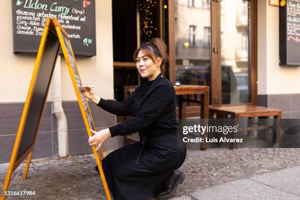 cafe owner writing today's special on the chalkboard - personal chef stock pictures, royalty-free photos & images