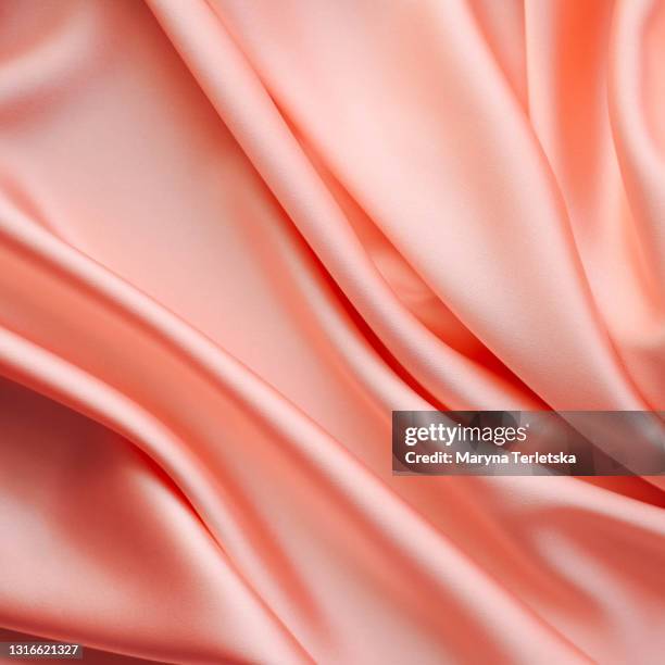 background from satin fabric of beige color. - silk cocoon stock pictures, royalty-free photos & images