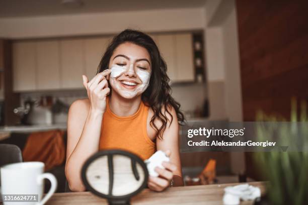 femme de sourire dans l’amour avec de nouveaux produits de soin de peau - mud mask photos et images de collection