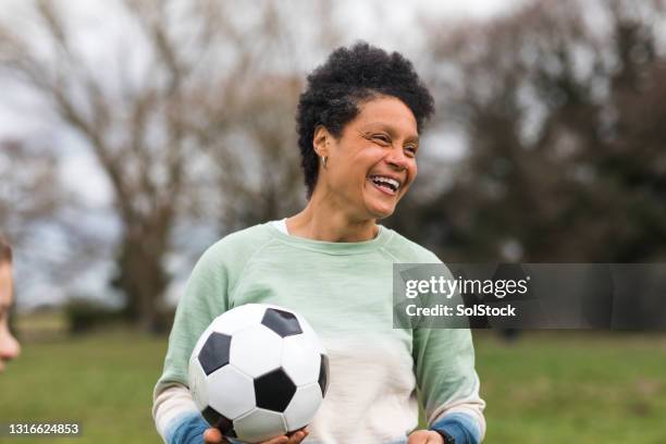 mature woman playing football - menopossibilities stock pictures, royalty-free photos & images