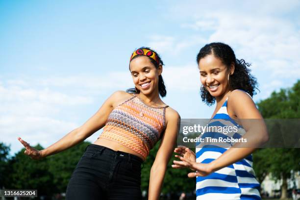 two friends dancing playfully outside - friendship necklace stock pictures, royalty-free photos & images