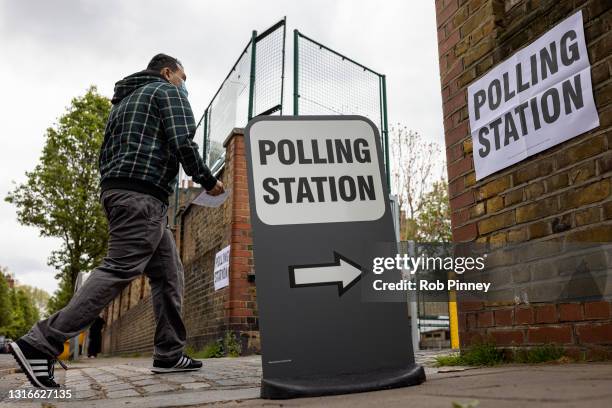 Man walks into a polling station at Walnut Tree Walk Primary School on May 06, 2021 in London, England. The London mayoral election takes place today...