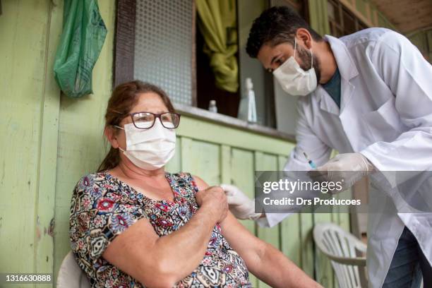 elderly woman taking the covid-19 vaccine at home. - rural health stock pictures, royalty-free photos & images