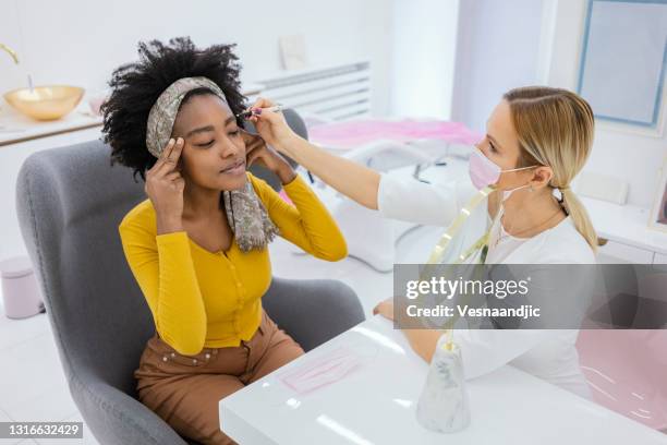 frau in absprache mit einem arzt ästhetiker in beauty-krankenhaus - schönheitsoperation stock-fotos und bilder
