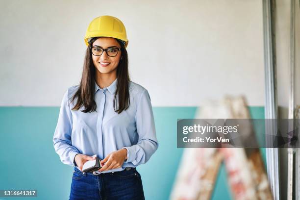 happy female architect standing in building site - architect object stock pictures, royalty-free photos & images