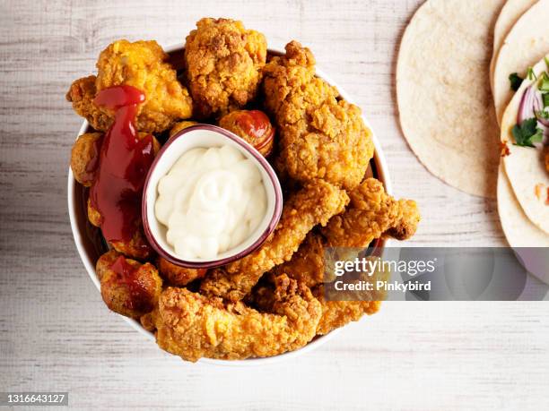 tiras de pollo frito, dedos y baquetas, tiras de pollo empanadas fritas crujientes, - breaded fotografías e imágenes de stock