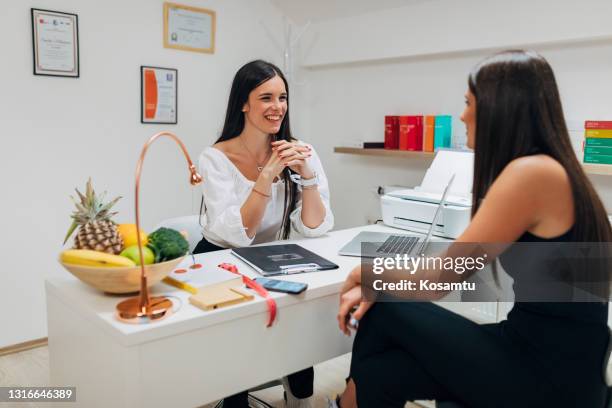 professionele vrouwelijke dietoloog die de medische geschiedenis van haar cliënt neemt, alvorens zij met dieetraadpleging beginnen - nutritionist stockfoto's en -beelden