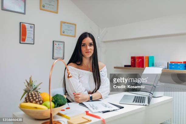 nutritionist and dietologist in her modern private clinic, ready to help people with eating disorders and obesity problems - high fibre diet stock pictures, royalty-free photos & images
