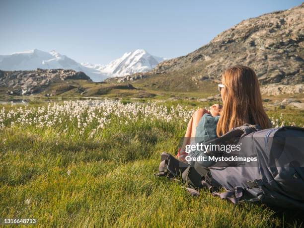 female hiker relaxes on meadow near alpine lake - valais canton stock pictures, royalty-free photos & images