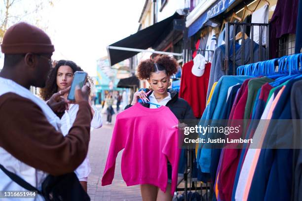 group of friends trying on vintage clothing and posing for pictures - vintage mode stockfoto's en -beelden