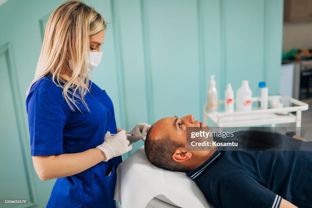 Moderne mittlere erwachsene Mann, Besuch der Schönheitsklinik für eine Haarbehandlung mit Kollagen und Vitamine schießt Behandlung