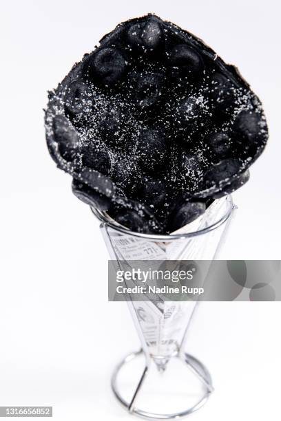 bubble waffel in schwarz mit puderzucker - puderzucker stock pictures, royalty-free photos & images