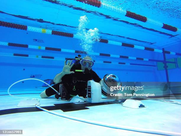 Getty Images staff photographer Al Bello poses as he sets up an underwater robotic camera during the 2016 U.S. Olympic Team Swimming Trials at...