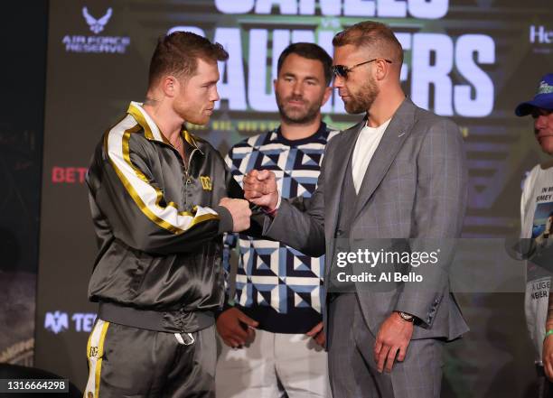 Canelo Alvarez and Billy Joe Saunders shake hands with Matchroom Promoter Eddie Hearn looking on during the press conference for Alvarez's WBC and...