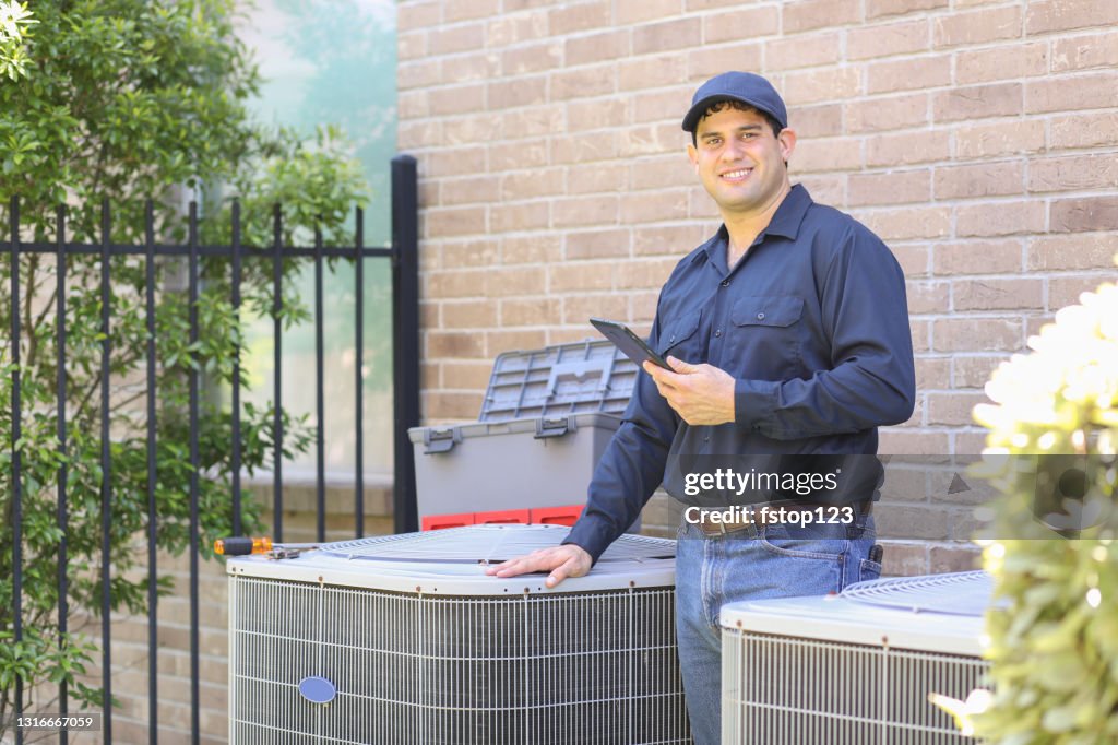 Descenso latino, reparador de aire acondicionado de cuello azul en el trabajo.