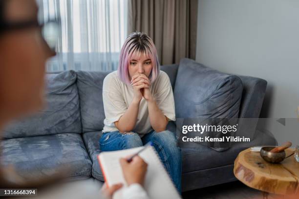 hopeless young woman talking with her therapist - hysteria imagens e fotografias de stock