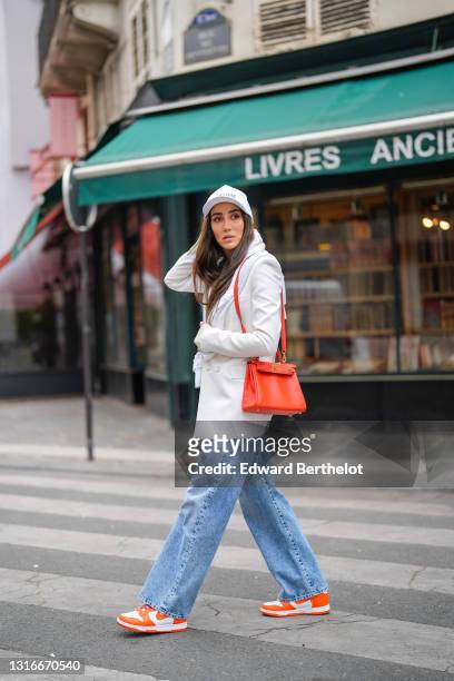 Tamara Kalinic wears a white Celine cap, a white latte ribs tank top, a white long Saint Laurent YSL blazer jacket, a white embroidered Chanel...