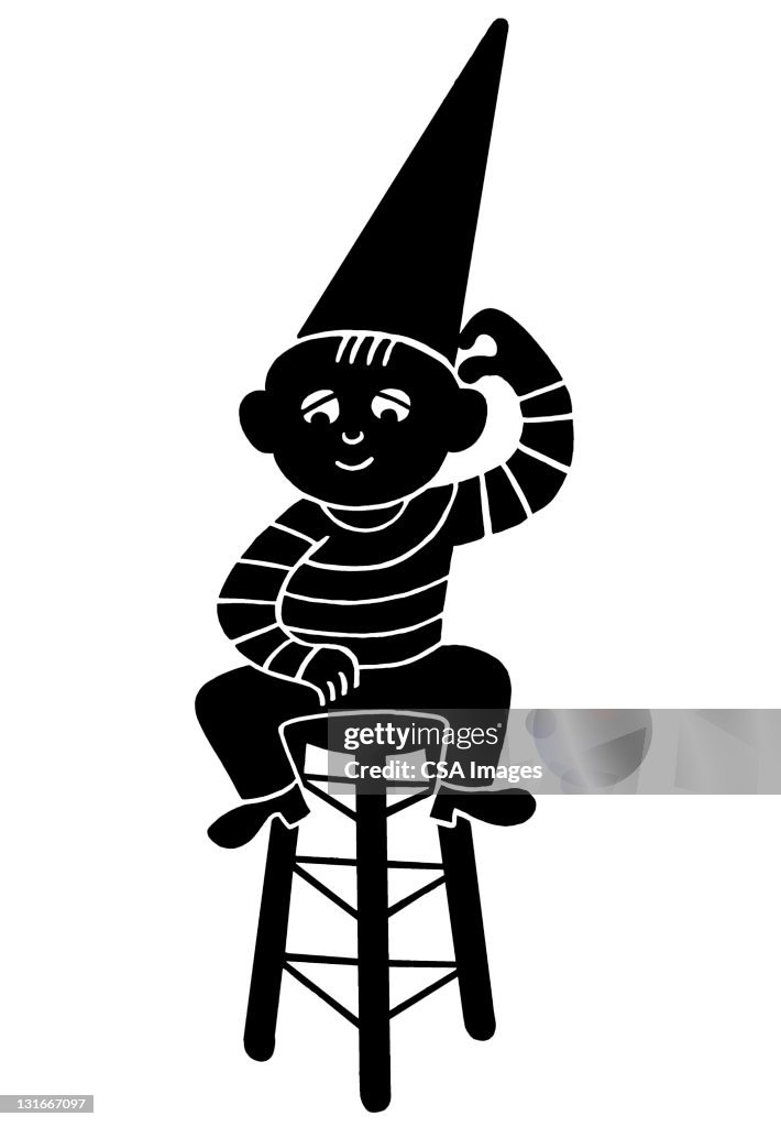 Boy Wearing Dunce Cap Sitting on Stool