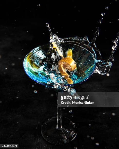 blue martini with orange slice splashing on top - vodka stock pictures, royalty-free photos & images