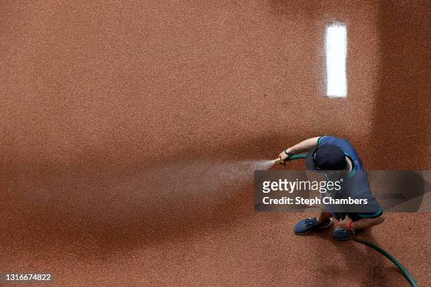 Groundskeeper waters the bullpen before the game between the Seattle Mariners and the Baltimore Orioles at T-Mobile Park on May 05, 2021 in Seattle,...
