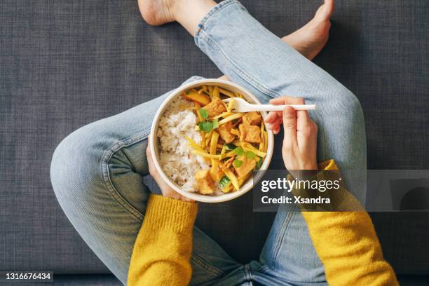 woman eating rice with tofu for lunch - rice grains stock pictures, royalty-free photos & images