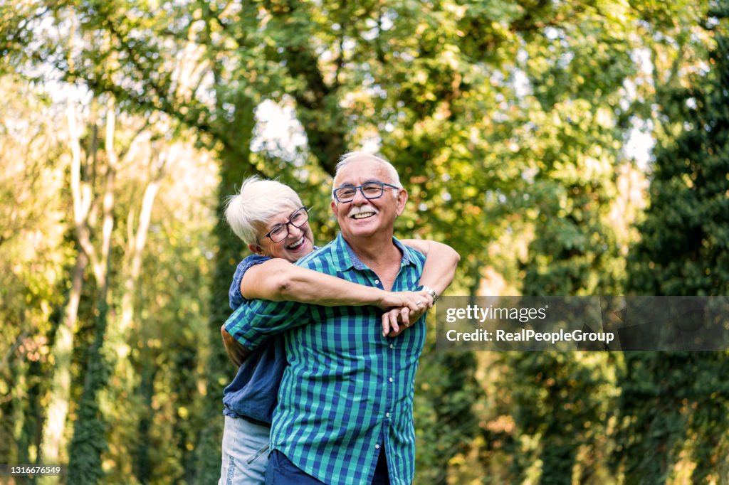 Portrait of beautiful senior couple hugging and posing in the spring park