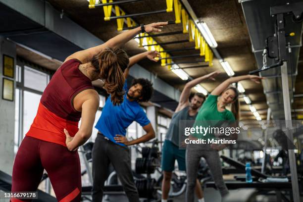 group of young people doing exercises in gym - aerobic stockfoto's en -beelden