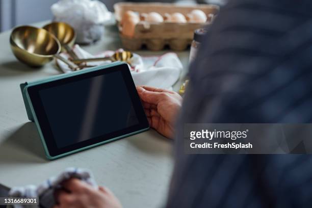 hände einer frau beobachten eine live-koch-sitzung auf ihrem tablet und folgen dem rezept (blank screen) - cake display stock-fotos und bilder
