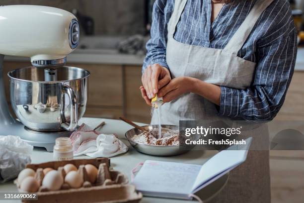 stap voor stap koekjes bakken: anonieme vrouw volgt een recept uit haar notitieboekje - baking reading recipe stockfoto's en -beelden