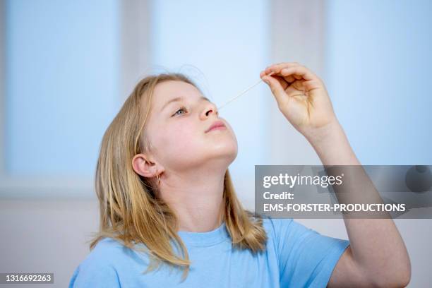 young teenager girl doing a corona self test at home - coronavirus test stock-fotos und bilder