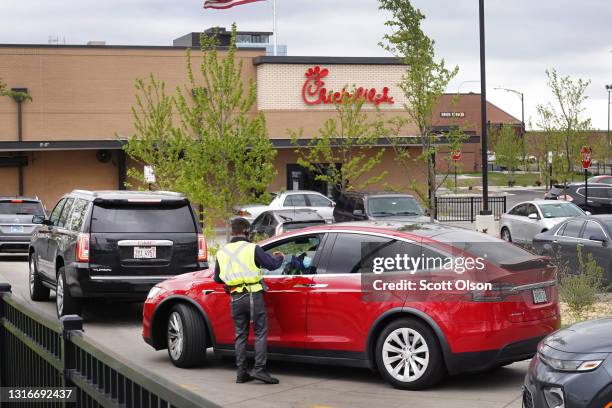 Worker takes orders as customers line up in the drive-thru lane at a Chick-fil-A restaurant on May 06, 2021 in Chicago, Illinois. Chicken prices have...