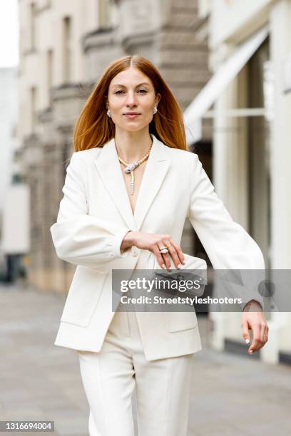 Influencer Lisa Banholzer wearing a white suit by Dorothee Schumacher, a white bag by Bvlgari, a yellow and white gold snake ring with diamond and...