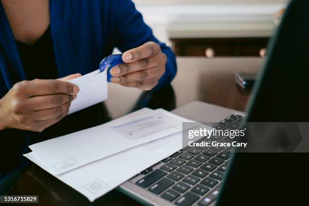 woman opens mail with letter opener - abrecartas fotografías e imágenes de stock