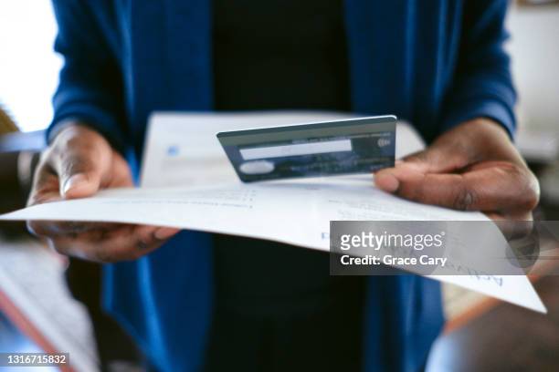 woman receives new credit card in mail - debit cards credit cards accepted stock pictures, royalty-free photos & images