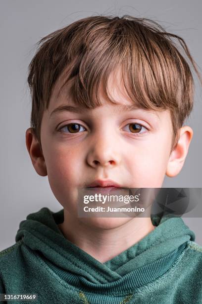 peinzend kaukasisch weinig jongen die de camera bekijkt - young face serious at camera stockfoto's en -beelden