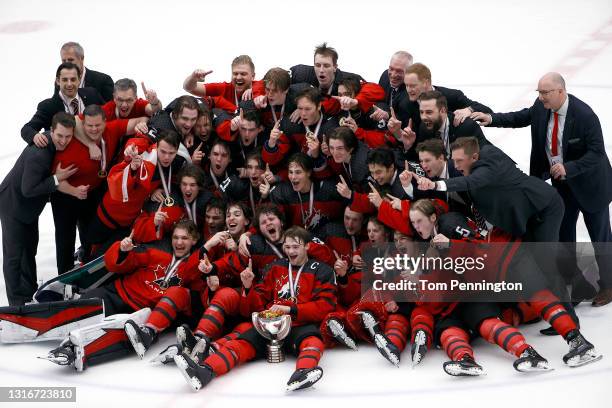 Team Canada celebrates with the championship trophy after defeating Russia 5-3 in the 2021 IIHF Ice Hockey U18 World Championship Gold Medal Game at...