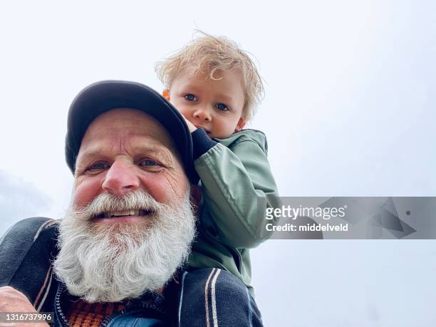 op opa schouder - seniors having fun with grandson stockfoto's en -beelden