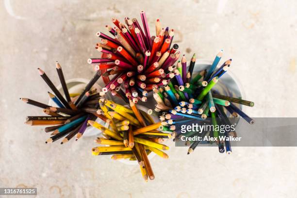 top down view of multi-coloured pencils in cups - pencil case stock pictures, royalty-free photos & images