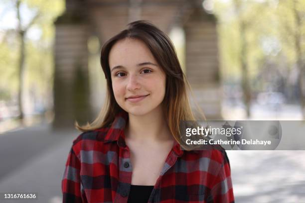 portrait of a teenage girl in the streets of paris - girl smiling stock-fotos und bilder
