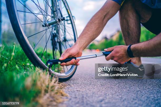 mens die fietswiel pompt - bicycle tire stockfoto's en -beelden